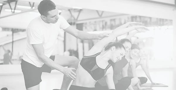 group of smiling women stretching in the gym